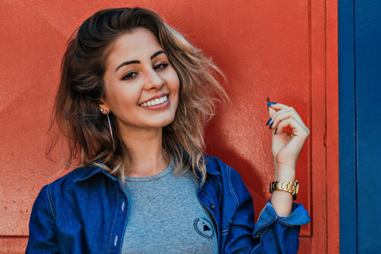 A smiling young woman showing off her dental veneers